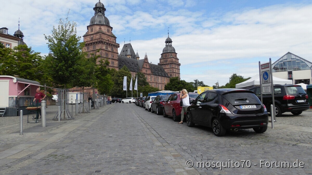 Neue Autos vor altem Gemäuer
