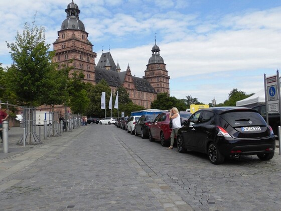 Neue Autos vor altem Gemäuer